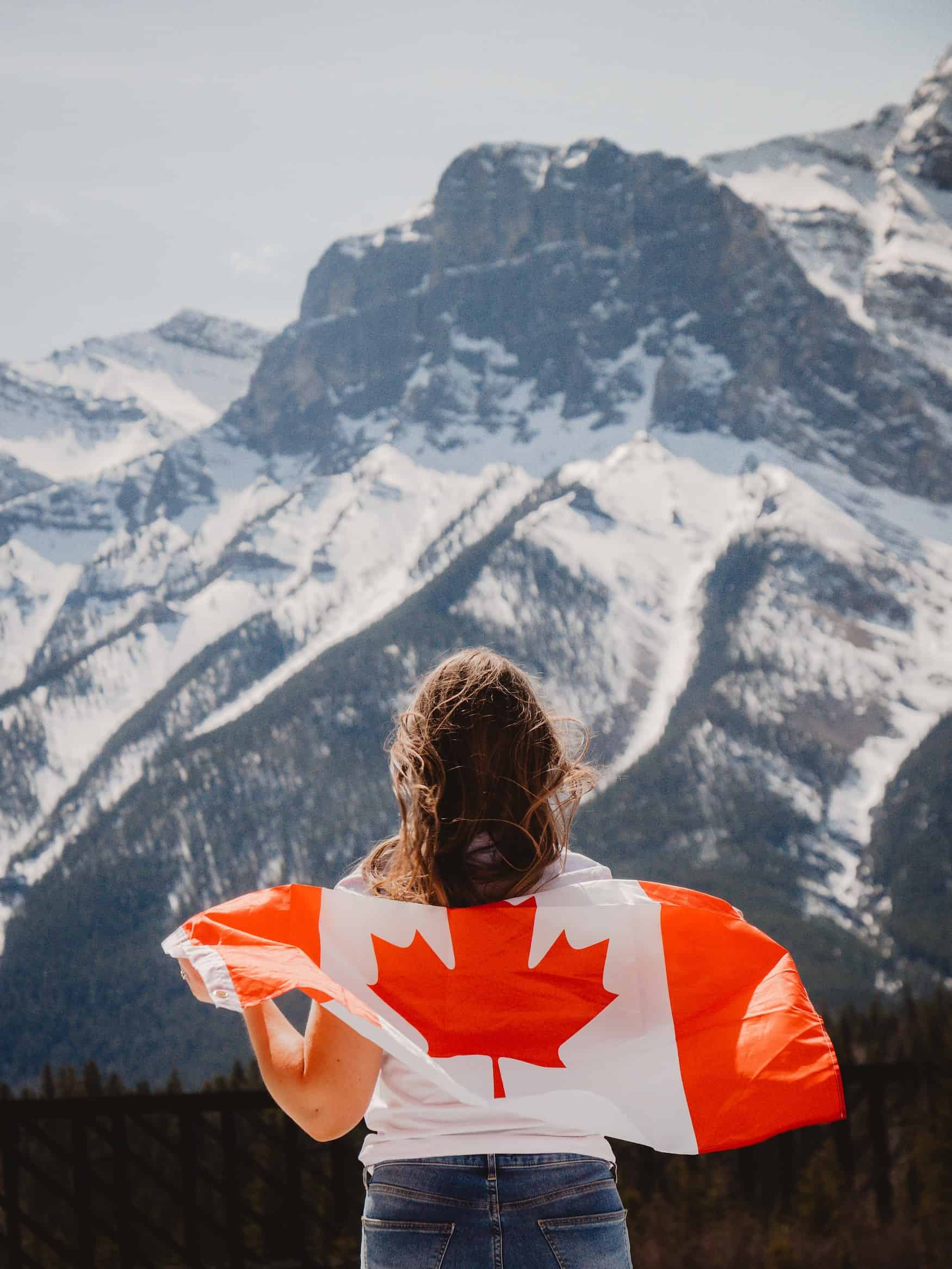 Frau trägt eine kanadische Flagge über den Schultern