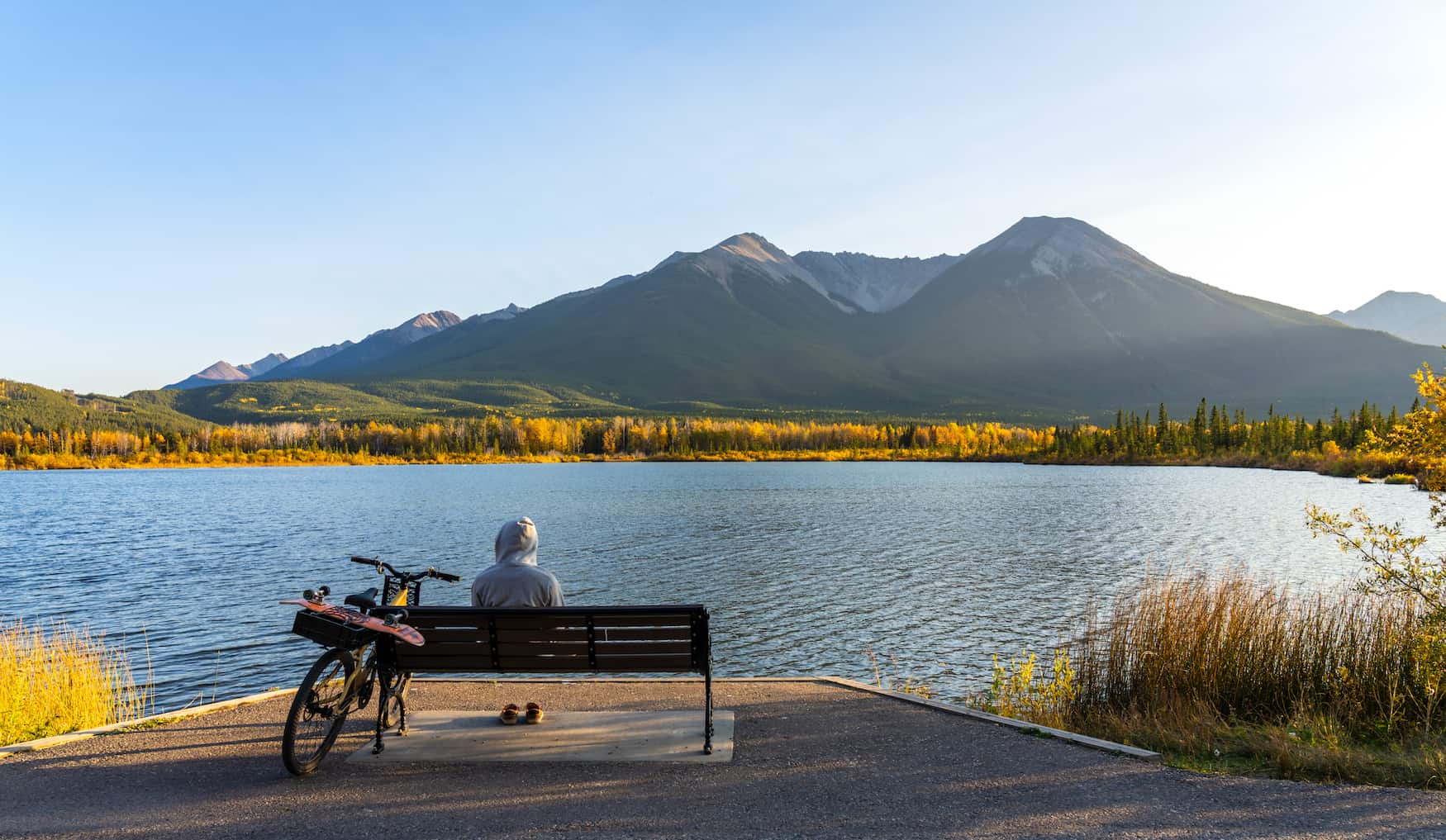 Tourist macht eine Pause auf einer Bank entlang des Banff Legacy Trails