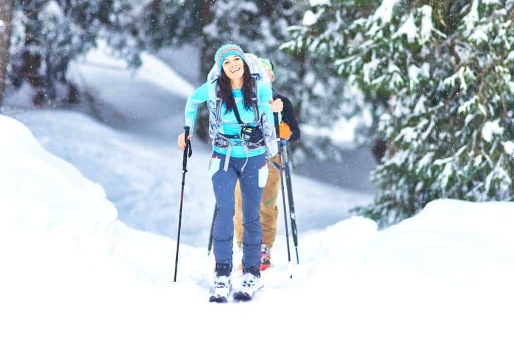Frau auf Telemark-Skiern streift durch den Schnee in Kanada