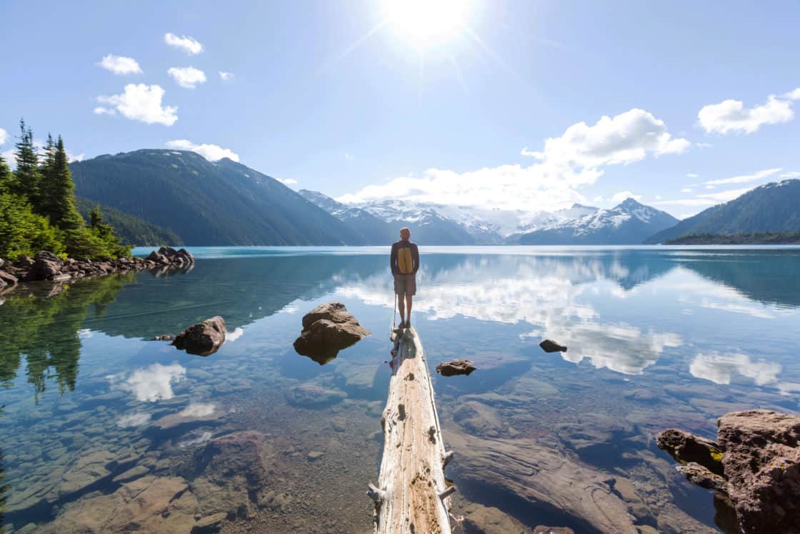 Mann steht auf Steg in einem See in Whistler im Frühling