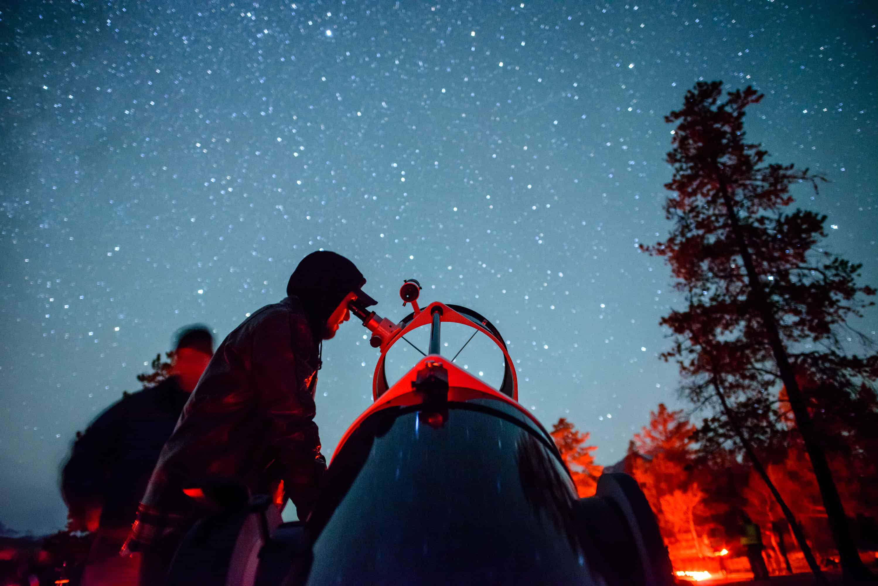 Menschen schauen sich Sterne bei Nacht an in einem Sternlichtreservat im Jasper Nationalpark