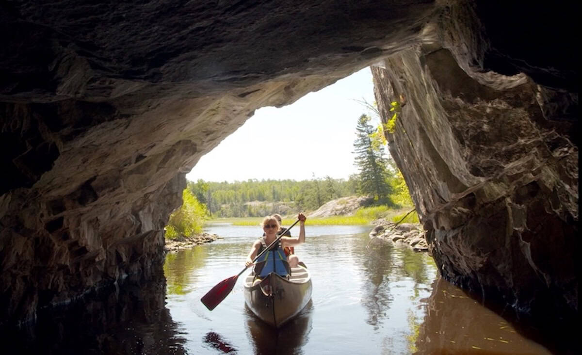 Menschen fahren mit dem Kanu durch die Höhlen am Ceddy Lake in Manitoba. 