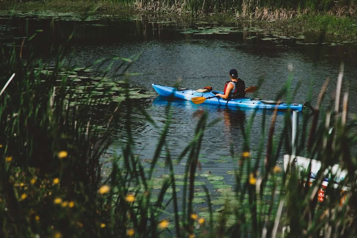 Person fährt Kanu über den Willow Creek am Winnipeg Lake in Manitoba.