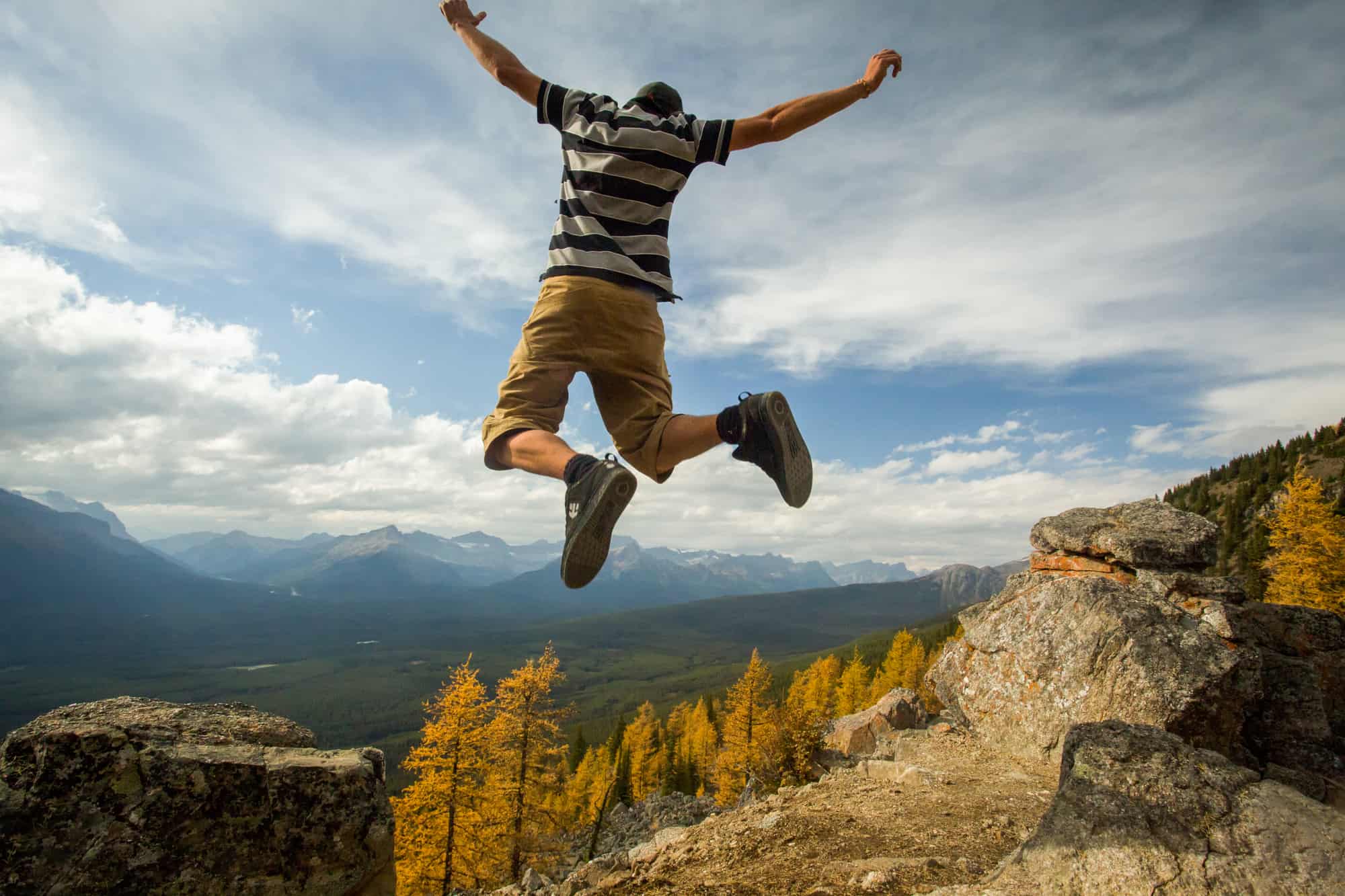 Mann hüpft vor der Kulisse des Banff Nationalparks in die Luft