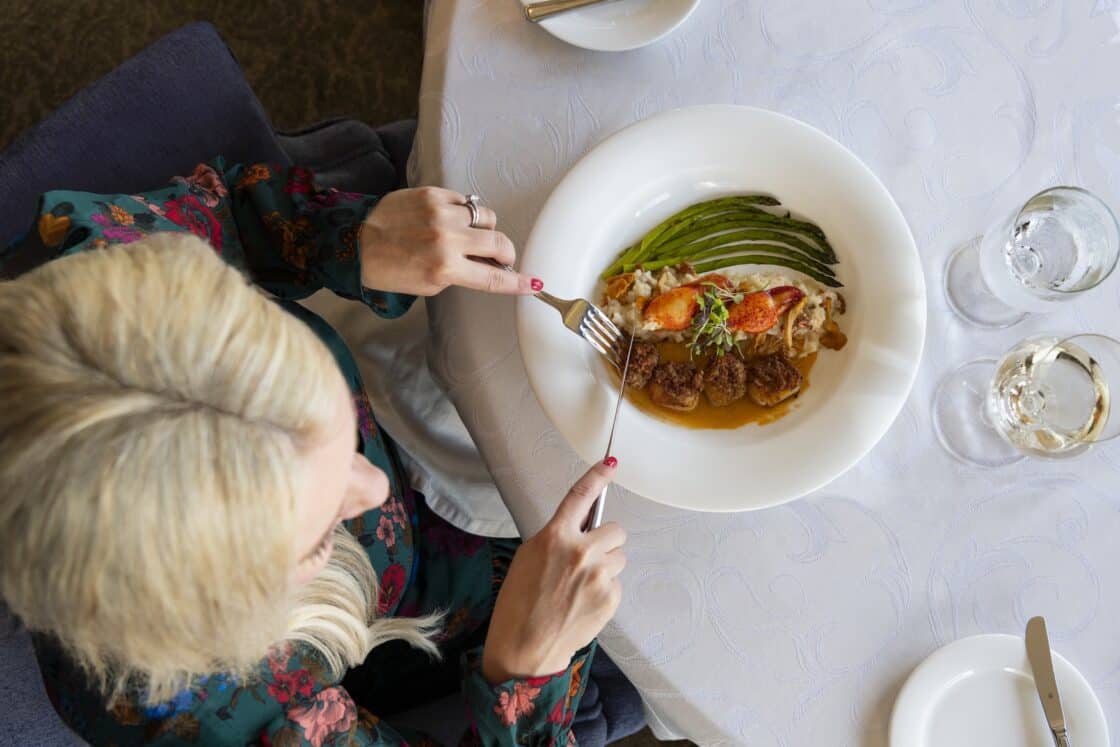 Frau genießt die Kulinarik in Nova Scotia im Restaurant des Fox Harbr Restorts