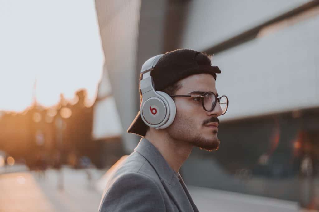 Junger Mann der mit Kopfhörern Musik hört