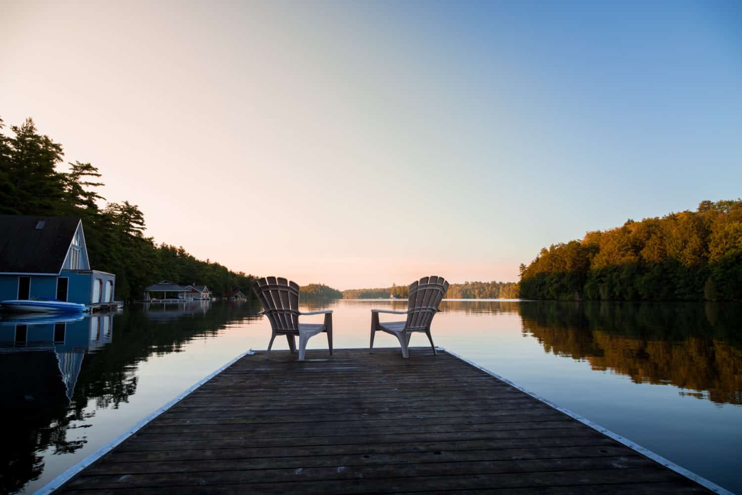 Muskoka-Stühle an Flussufer im Cottage Country in Kanada