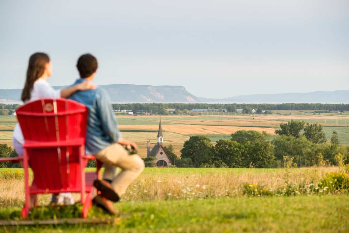Besucher auf roten Stühlen am Grand-Pré Park. Eine UNESCO Weltkulturerbe.