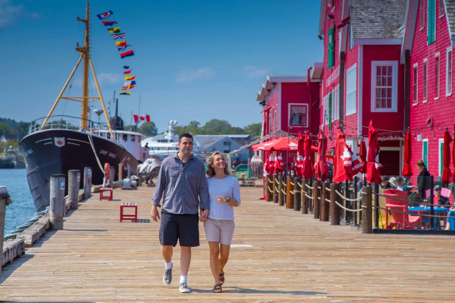 Paar spaziert an einem Pier in Nova Scotia entlang zum Fischerei Museum