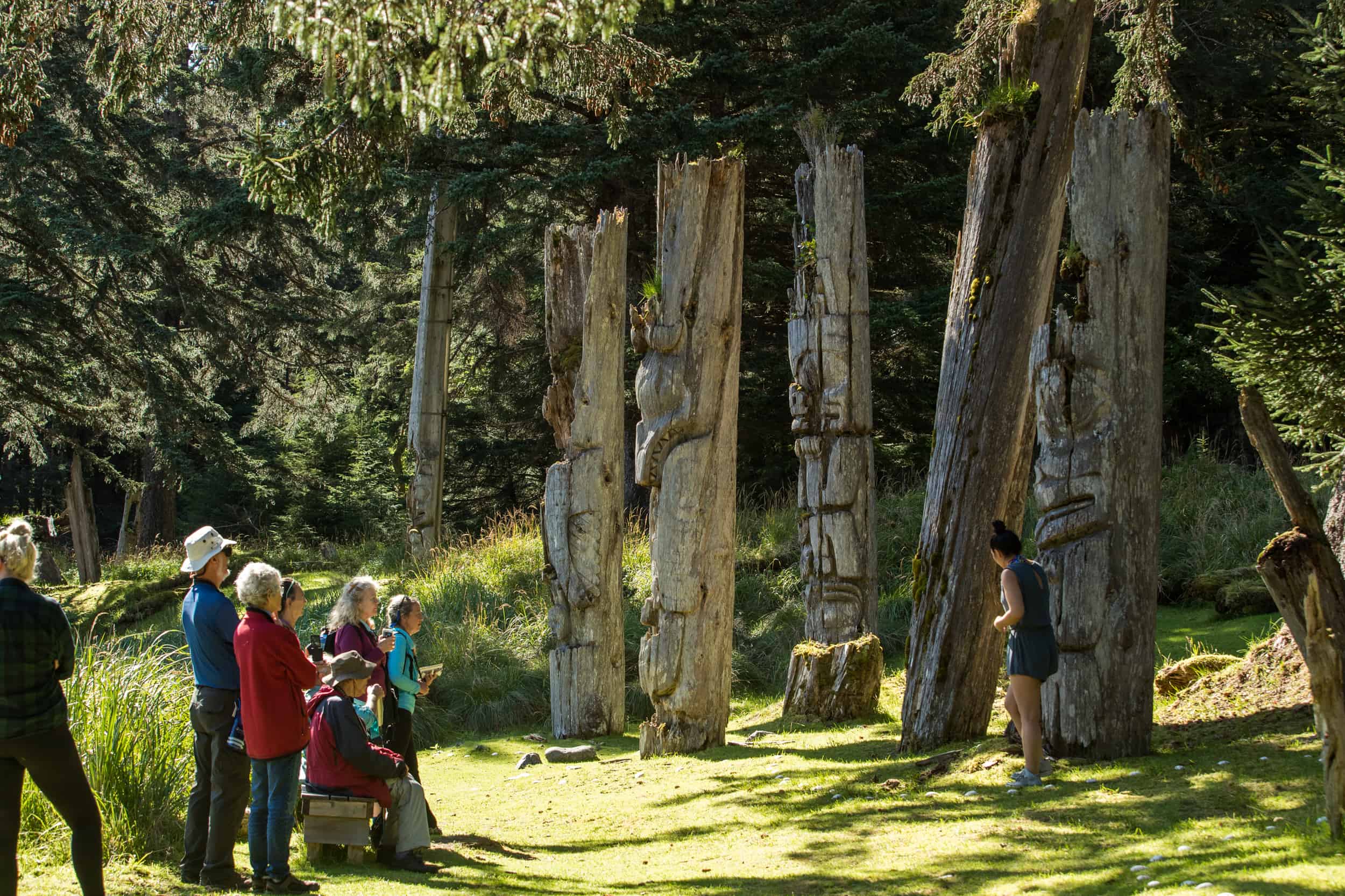Touristen vor alten Totem