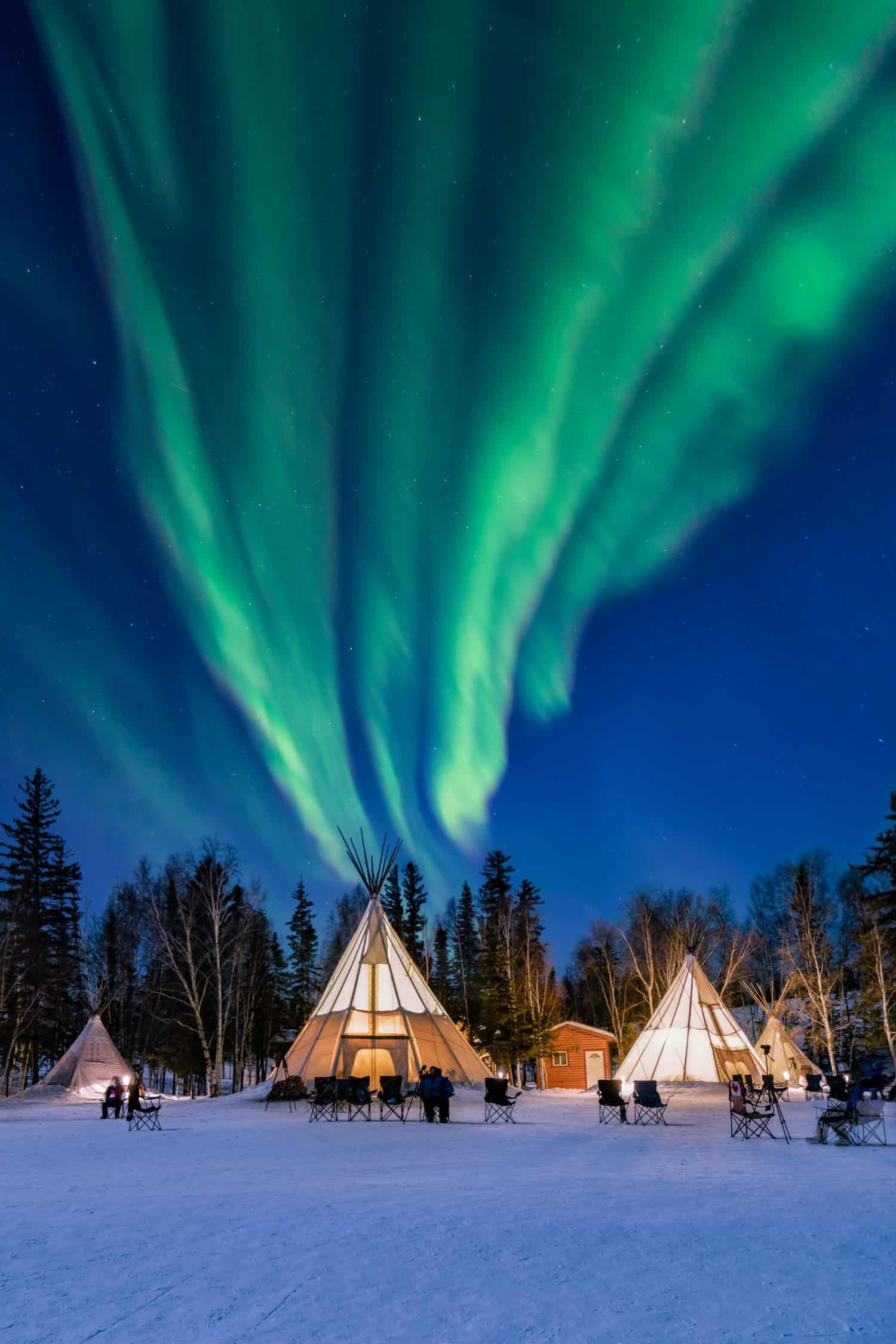 Aurora borealis über Zelten in verschneiter Landschaft von Nunavut
