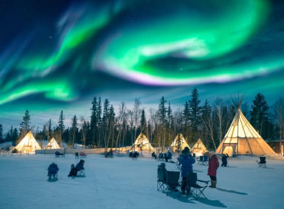 beeindruckende Nordlichter tanzen über den Zelten im Aurora Village in Yellowknife, Kanada.