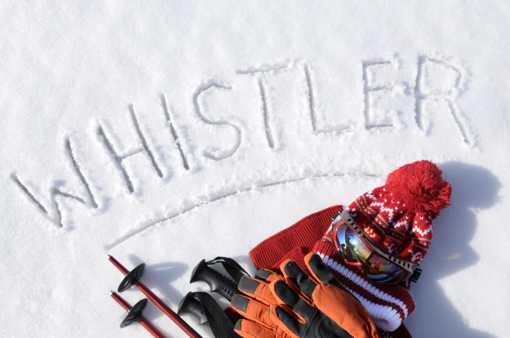 Im Schnee liegende Skisachen. Über den Sachen steht in den schnee geschrieben Whistler