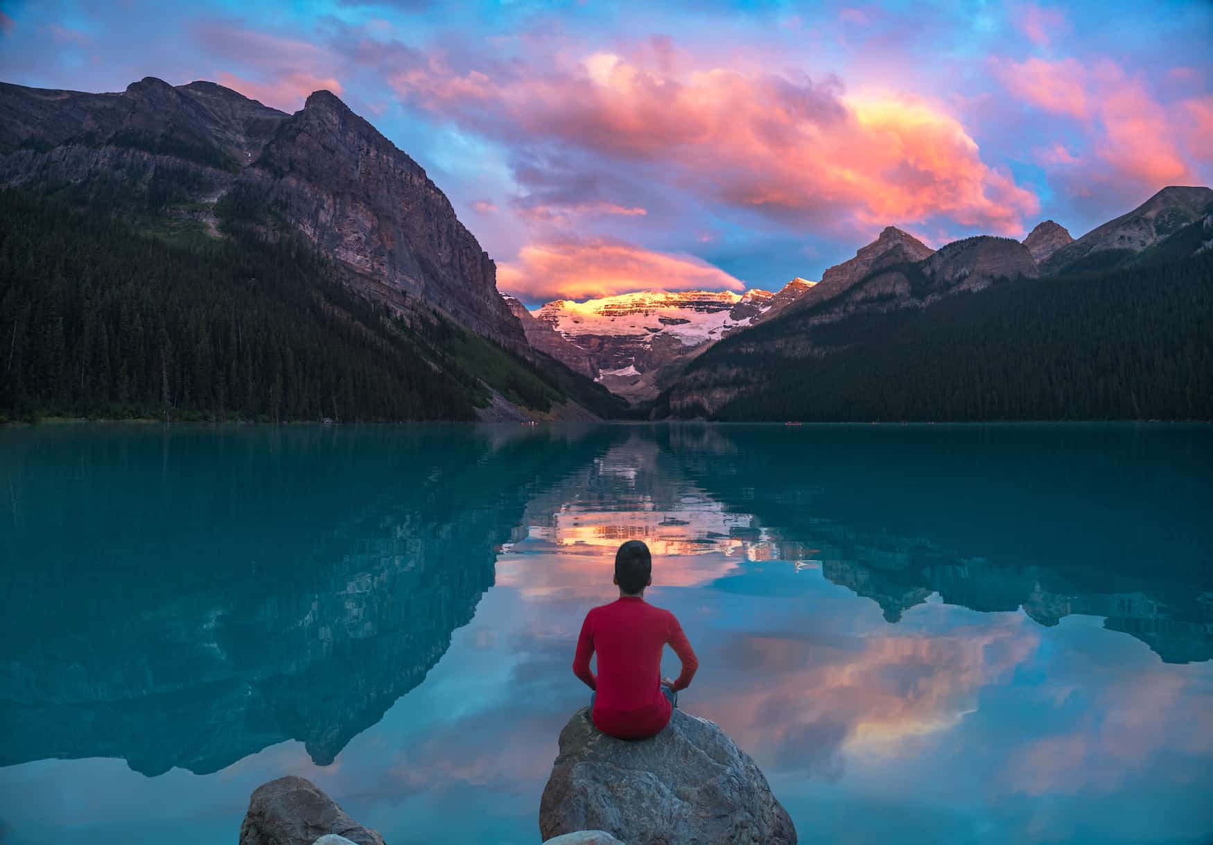 Junge vor der malerischen Kulisse des Lake Louise mit den Canadian Rockies im Hintergrund