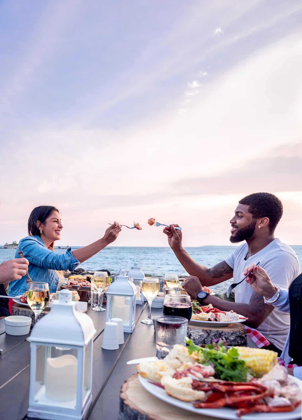 Freundesgruppe bei einem Lobster Dinner an der Küste von Nova Scotia