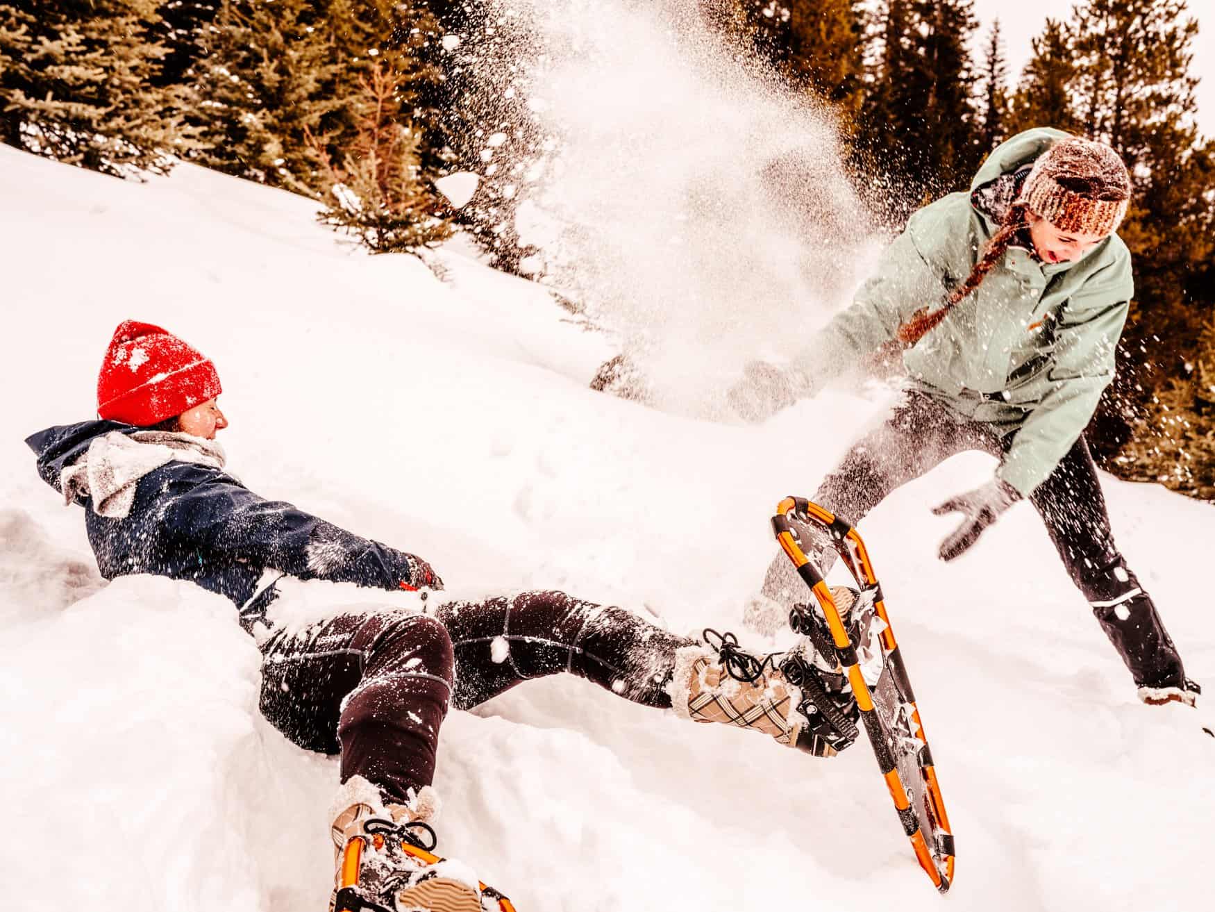 Zwei Mädchen albern rum beim Schneeschuhwandern in den Rocky Mountains
