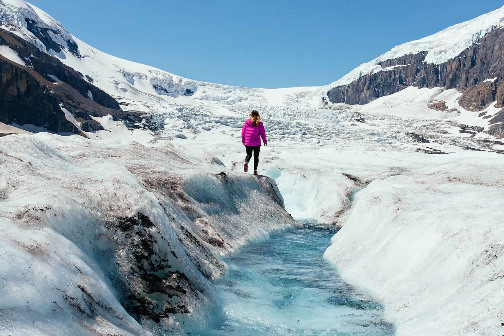 Frau wandert durch den Athabasca Gletscher in Alberta