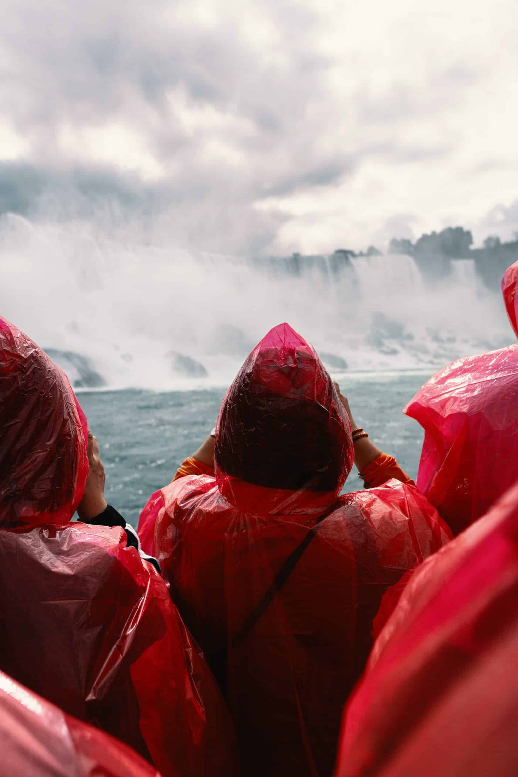 Besucher in roten Regencapes an Wasserfällen in Kanada
