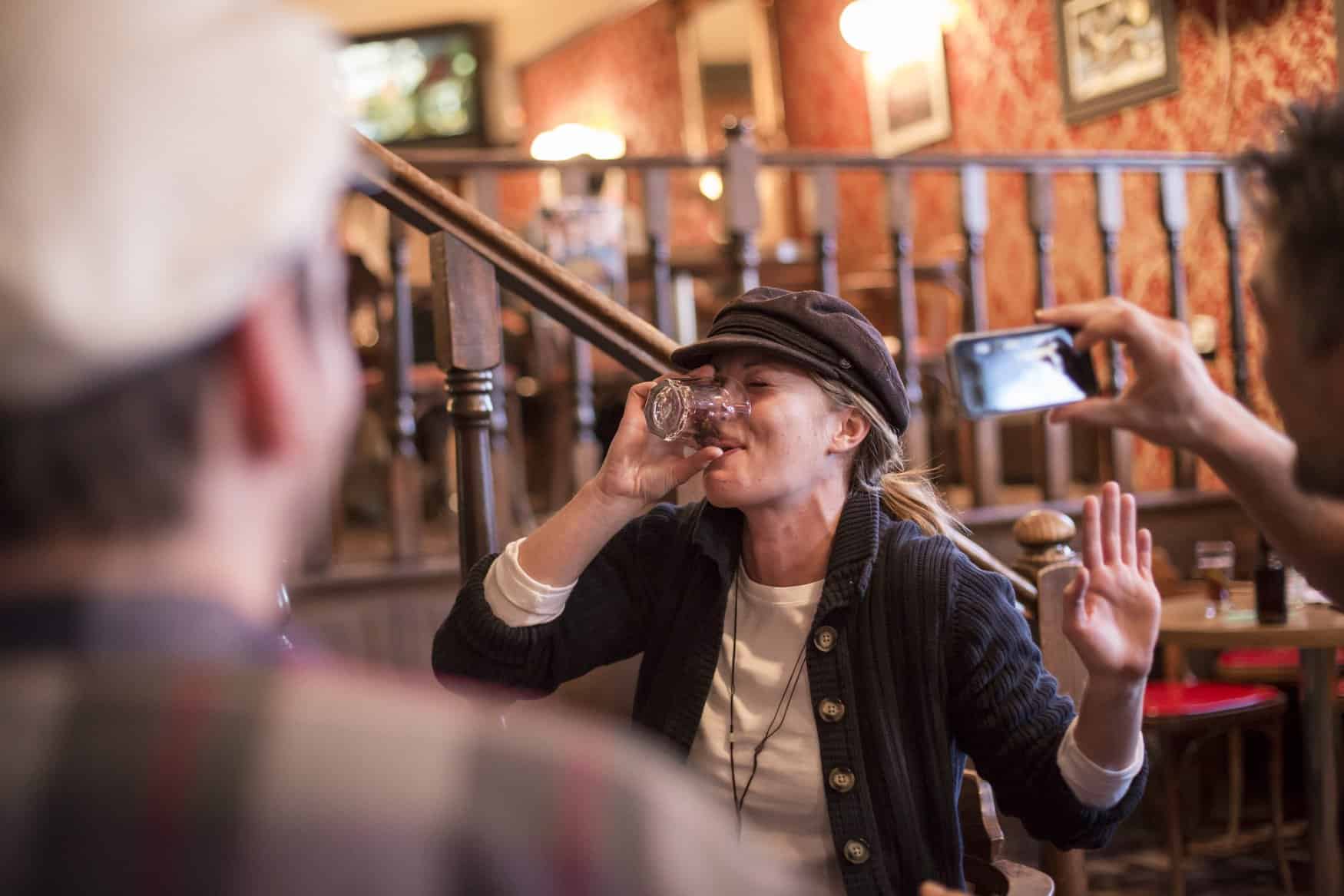 Frau trinkt Sourtoe Cocktail im Downtown Hotel in Dawson City