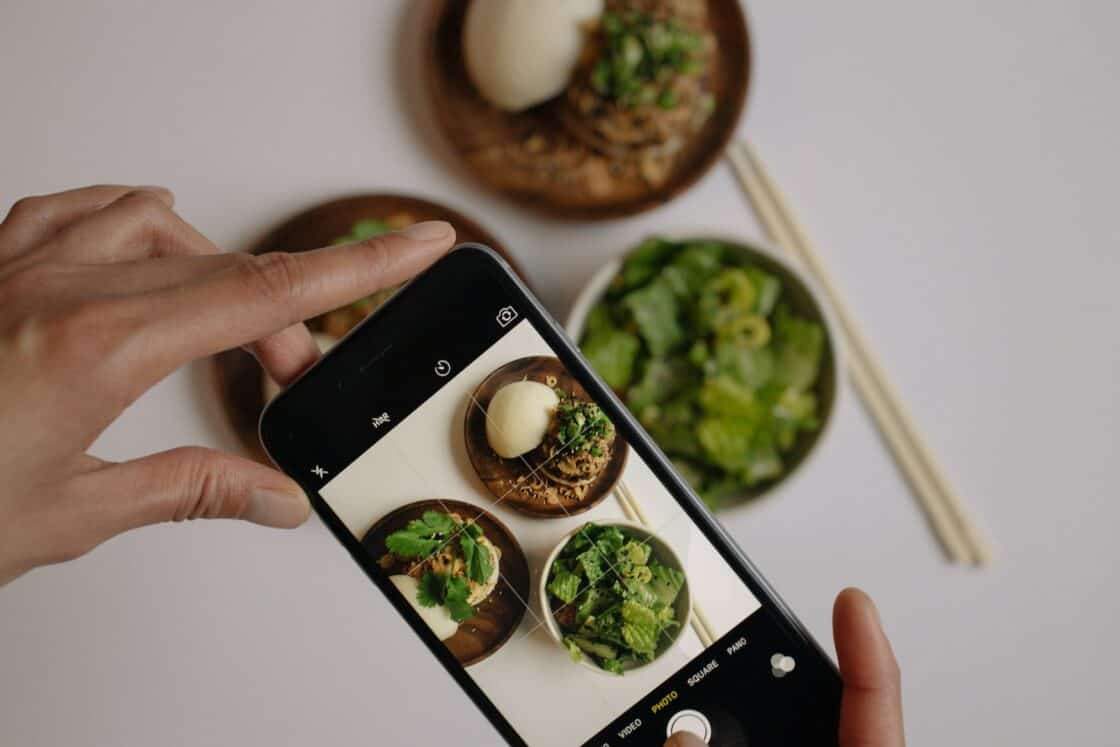 Person fotografiert Essen mit Smartphone