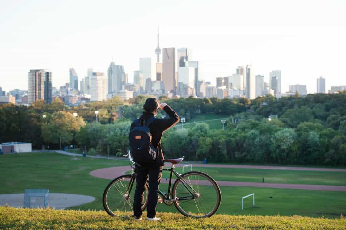 Toronto ist ganz schön grün. Frau mit Fahrrad guckt auf die Stadt