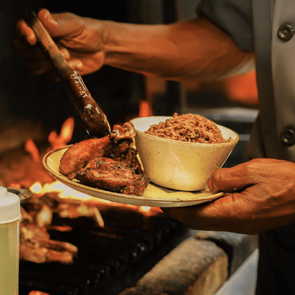 Gegrilltes Fleisch mit Reis wird angerichtet in Chubby's Jamaican Kitchen, einem jamaikanischen Restaurant