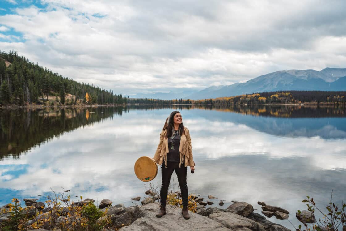 Patricia Bauer von Warrior Women hält eine Trommel in der schönen Natur von Kanada
