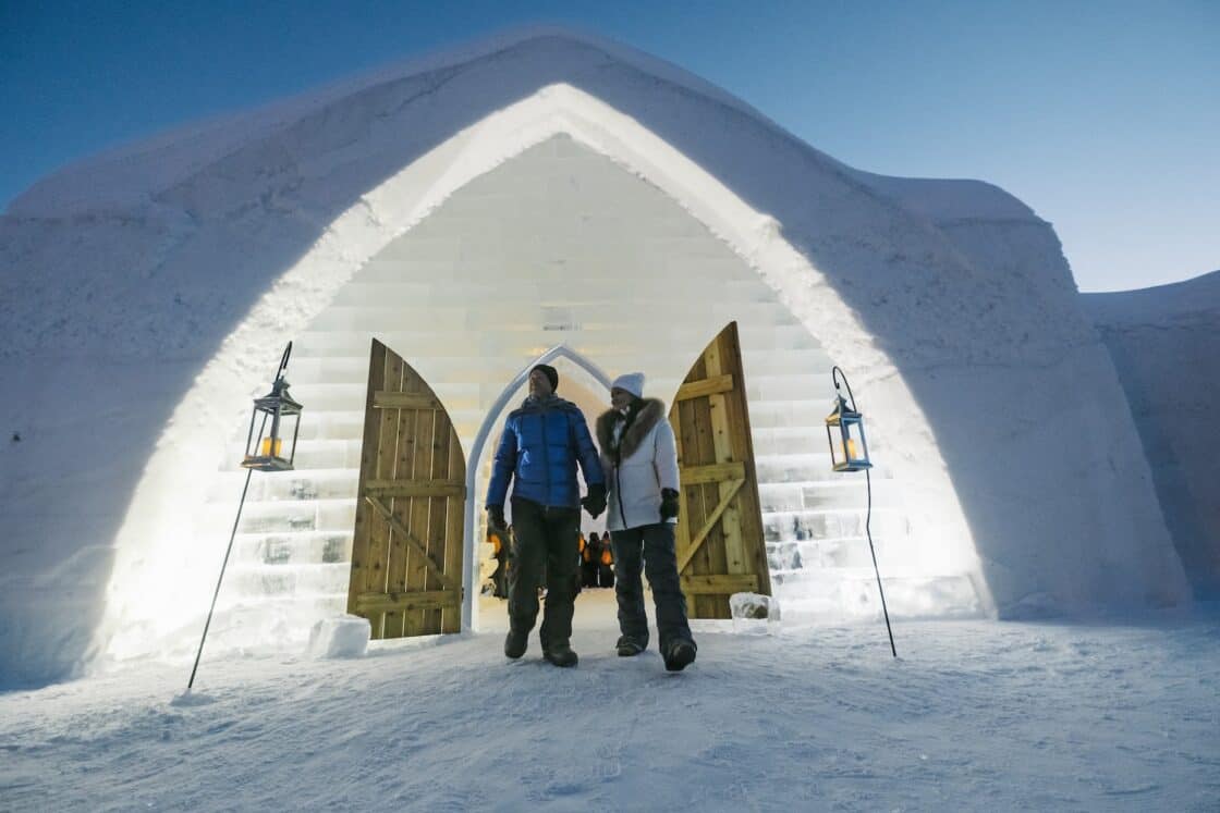 Zwei Menschen stehen vor einem Iglu beim Hotel de Glace in Quebec