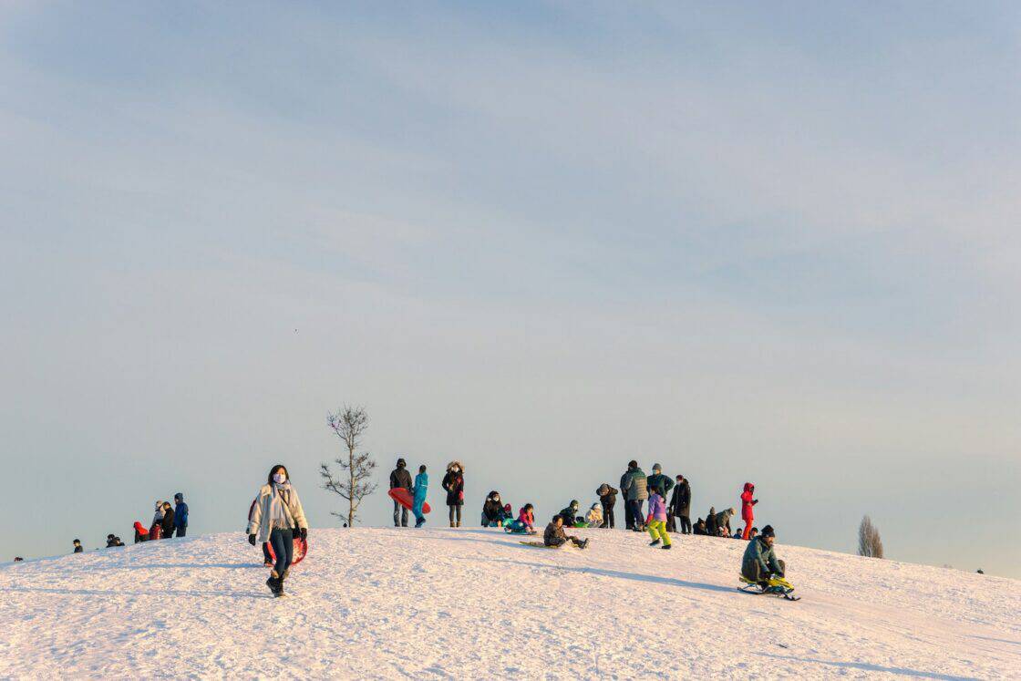 Menschen fahren Schlitten auf einem Hügel in Kanada