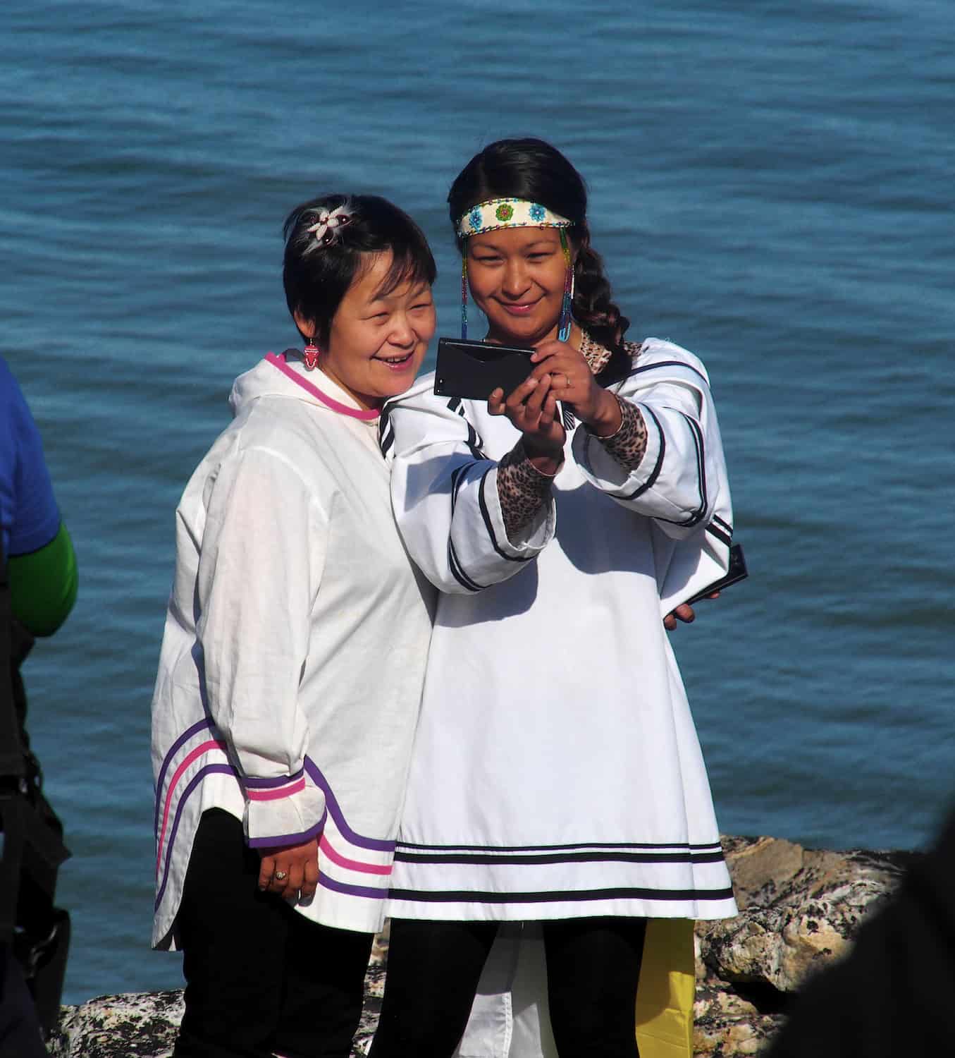 Zwei Menschen in indigener Kleidung machen ein Selfie