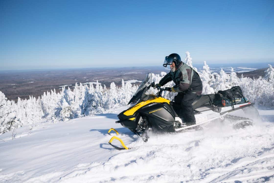 Mann fährt mit Schneemobil in Québec.