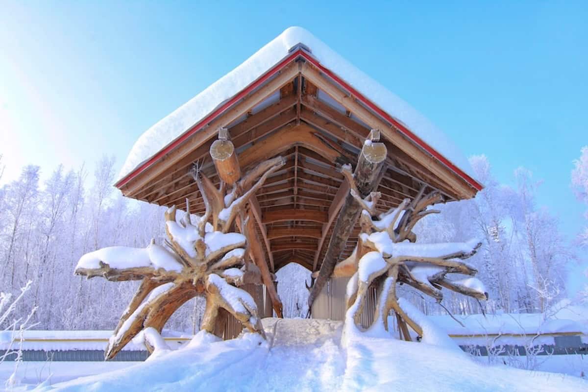 Kunstvolle Log Bridge in Norman Wells im Schnee.