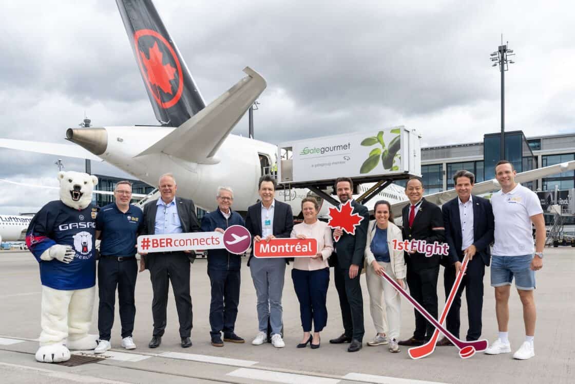 Zentrale Personen für den Direktflug zwischen Berlin-Montréal stehen vor einem Flugzeug von AirCanada.