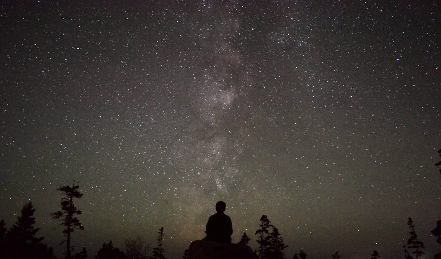 Person schaut in den Sternenhimmel im Naturresort Au Diable Vert in Sutton.