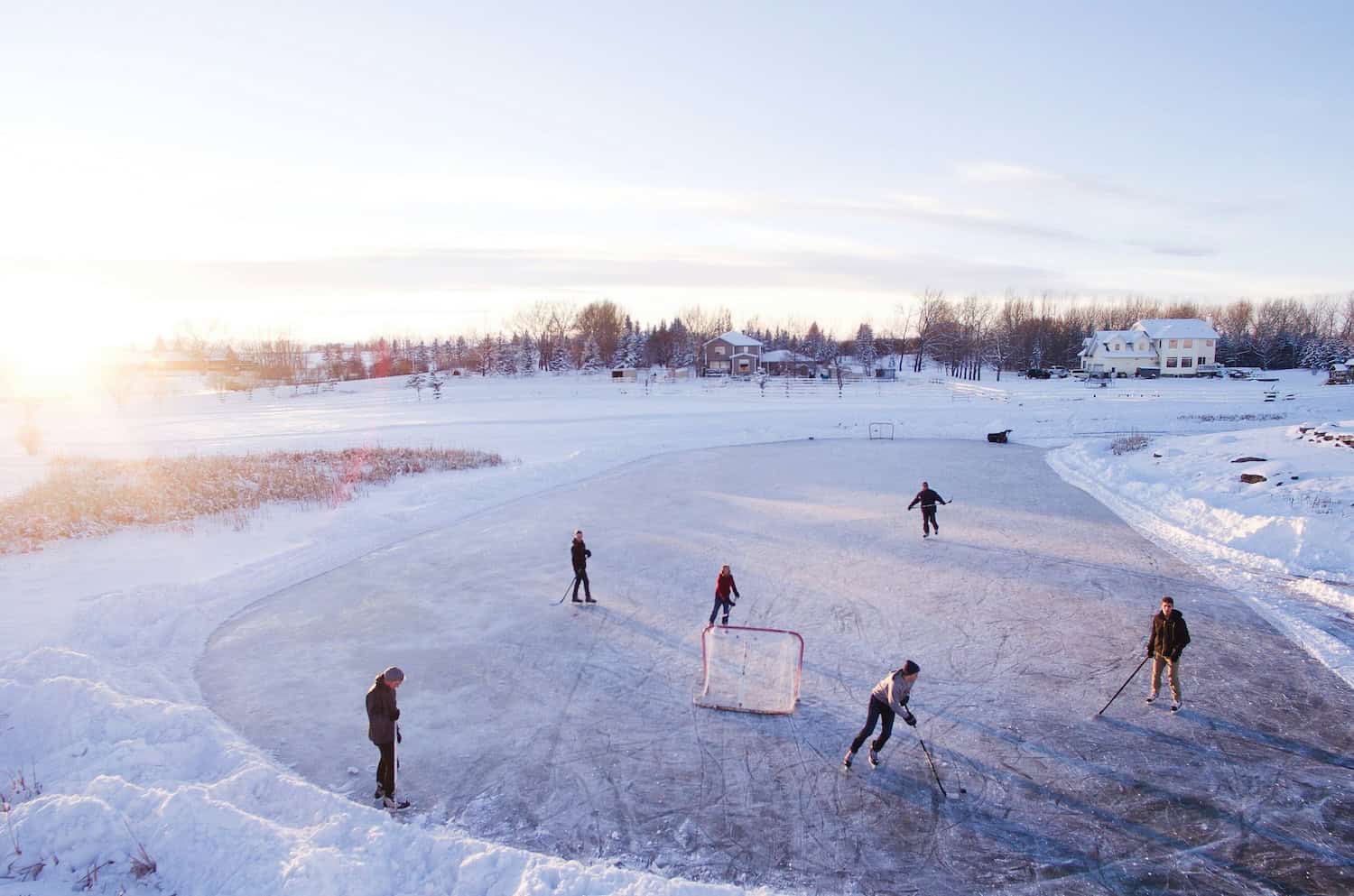 Menschen spielen Hockey auf zugefrorenem See.